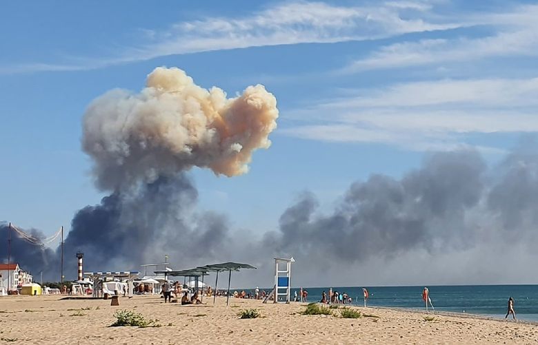Rising smoke can be seen from the beach at Saky after explosions were heard from the direction of a Russian military airbase near Novofedorivka, Crimea, Tuesday Aug. 9, 2022. The explosion of munitions caused a fire at a military air base in Russian-annexed Crimea Tuesday but no casualties or damage to stationed warplanes, Russia’s Defense Ministry said. (UGC via AP) TH801 TH801