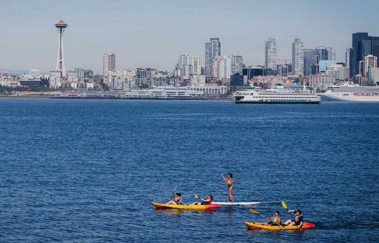 People paddle out on Elliott Bay, off the edge of Downtown Seattle, on August 15, 2022. 221294