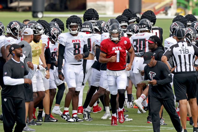 Atlanta Falcons quarterback Marcus Mariota (1) and tight end Kyle Pitts (8) break the huddle with fellow players during NFL football training camp, Tuesday, Aug. 2, 2022, in Flowery Branch, Ga. (Jason Getz/Atlanta Journal-Constitution via AP)