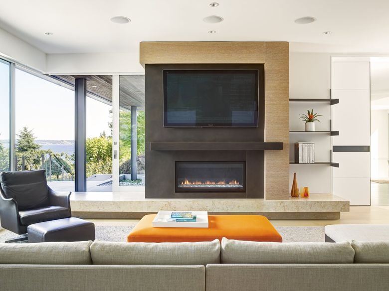 When TVs and fireplaces compete as the focal point of a room, &#8220;You can put the TV above the fireplace, or you can put it on the side,&#8221; says Stuart Silk of Stuart Silk Architects. &#8220;I have seen, and we considered it once, having it pop up out of the floor in front of the fireplace, so there’s all kinds of creative potential. We aim to integrate these two important elements into a single composition, as we did for this contemporary home on Mercer Island.&#8221; (Alex Hayden / Courtesy Stuart Silk Architects)