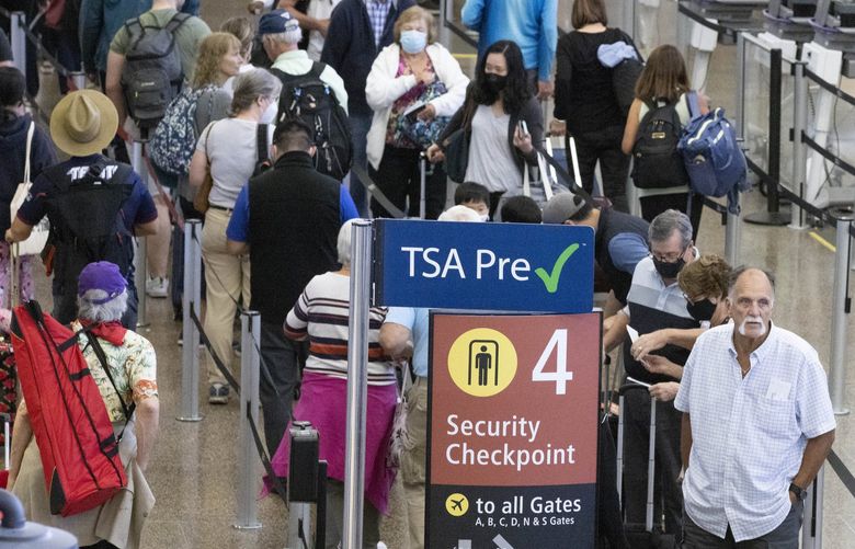 Travelers wait in long security lines at Seattle-Tacoma International Airport Friday, July 1, 2022 at the start of the 4th of July weekend.  Flights are more expensive but a lot of people are still traveling. 220887