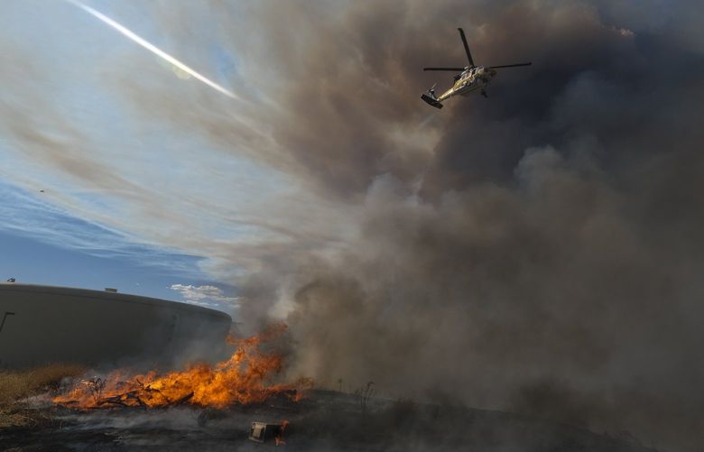 A helicopter drops water on a wildfire in Castaic, Calif. on Wednesday, Aug. 31, 2022. (AP Photo/Ringo H.W. Chiu) NYOTK NYOTK
