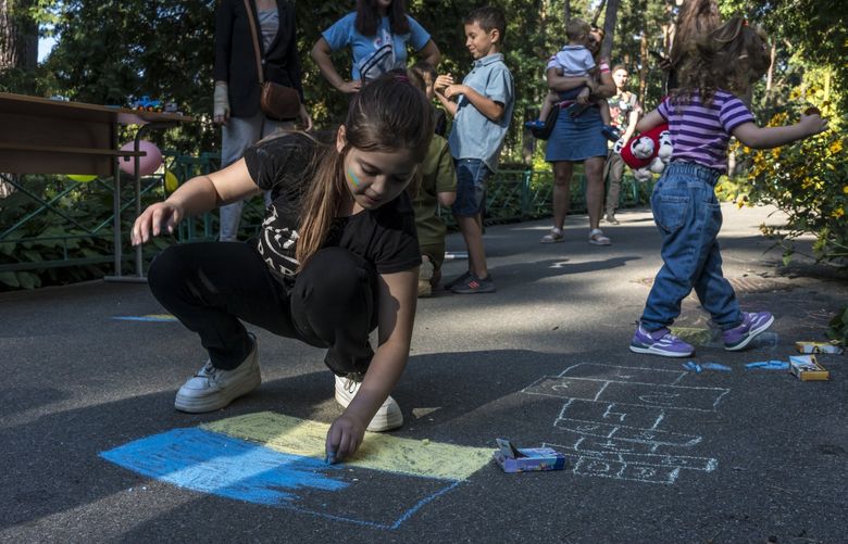 Milana draws a Ukrainian flag with chalk during a back-to-school event in Bucha, Ukraine on Aug. 31, 2022. An estimated 2.8 million of Ukraine’s six million children have been forced from their homes because of the Russian invasion. (Brendan Hoffman/The New York Times) XNYT65 XNYT65