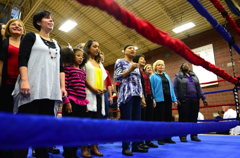 Райт и евангельский хор Total Experience выходят на ринг, чтобы исполнить национальный гимн перед четвертым ежегодным боксерским возрождением в Центральном округе в 2013 году. (Линдси Уоссон / The Seattle Times)