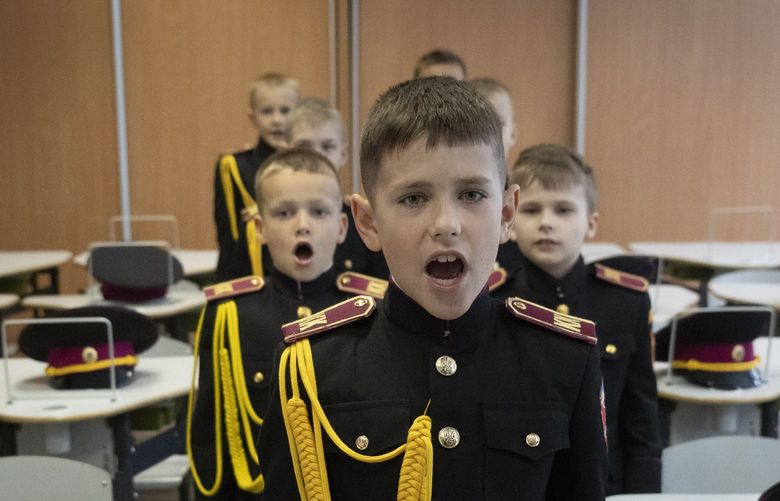 Young cadets greet a teacher on the first day of school at a cadet lyceum in Kyiv, Ukraine, Thursday, Sept. 1, 2022. (AP Photo/Efrem Lukatsky) XEL113 XEL113