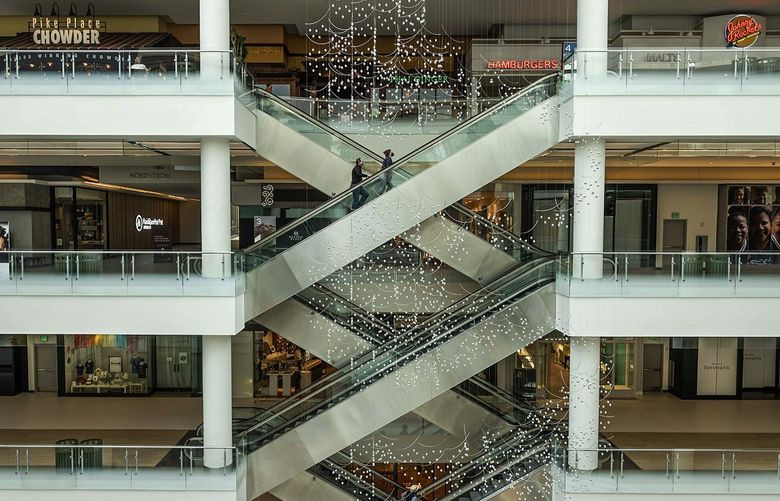 Mall customers ride the escalator up floors at Pacific Place in Seattle on Friday, May 13, 2022. The developer of Pacific Place filed preliminary documents to convert most of the retail space to offices on Wednesday. Converting the mall is estimated to cost $260 million.