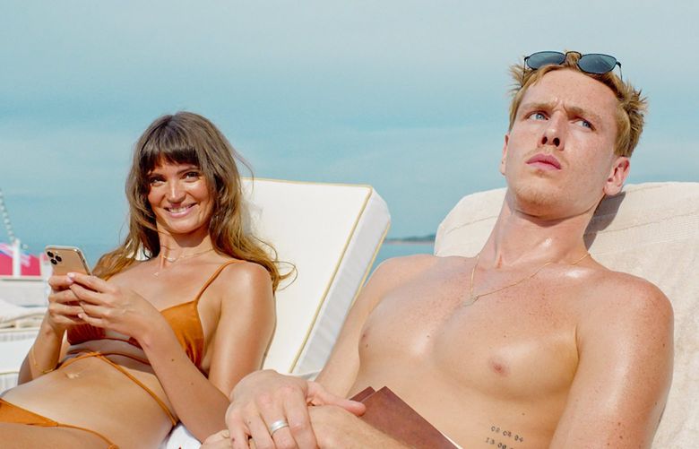 This image released by Neon shows Charlbi Dean Kriek, left, and Harris Dickinson in a scene from “Triangle of Sadness.” (Neon via AP) NYET952