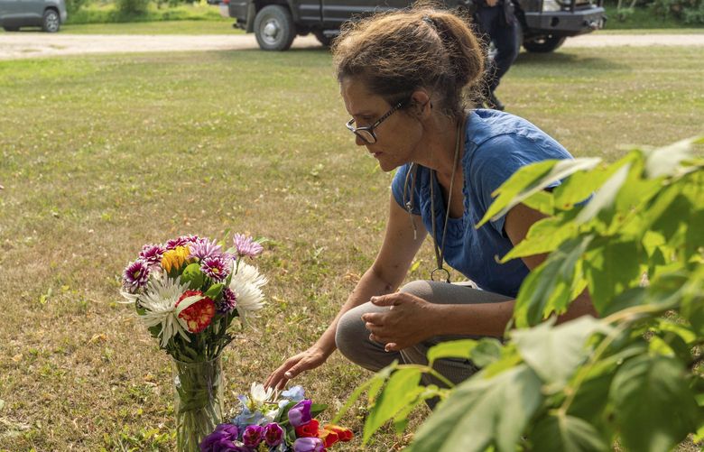 Ruby Works places flowers at the home of a victim who has been identified by residents as Wes Petterson in Weldon, Saskatchewan, on Monday, Sept. 5, 2022. Works said that the 77-years-old victim was like an uncle to her. Saskatchewan RCMP say arrest warrants have been issued for two suspects in a deadly stabbing rampage who remain at large. (Heywood Yu/The Canadian Press via AP) HCY105 HCY105