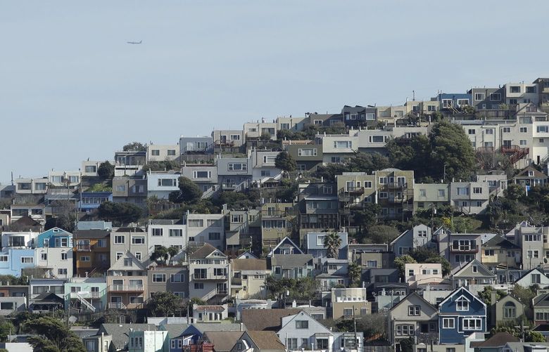 A plane flies over homes and residential buildings in San Francisco, in 2020.  (AP Photo/Jeff Chiu, File ) 