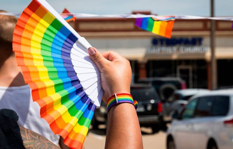 A No Hate in Texas protester holds up a fan while protesting Stedfast Baptist Church in July. (Yffy Yossifor/Fort Worth Star-Telegram/TNS)