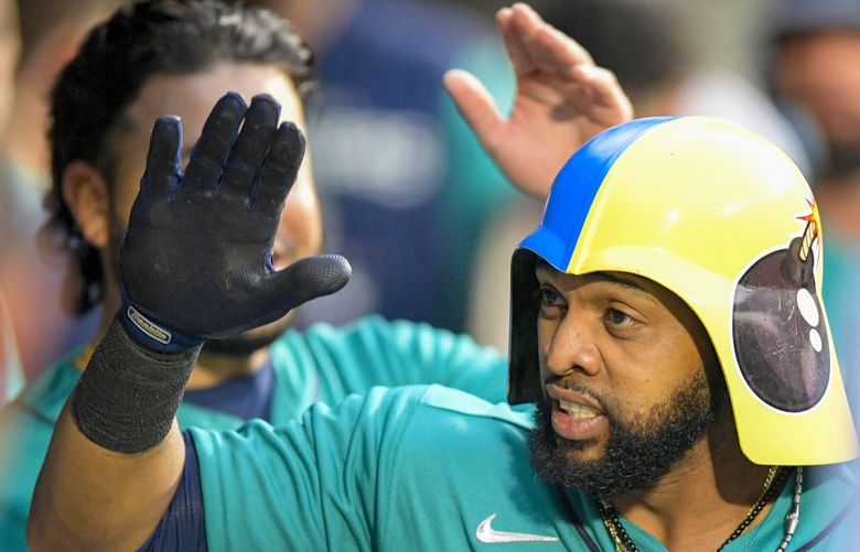 Seattle Mariners’ designated hitter Carlos Santana celebrates in the dugout after hitting a two-run home run during the second inning of a baseball game against the Atlanta Braves, Friday, Sept. 9, 2022, in Seattle. (AP Photo/Caean Couto) WACC106