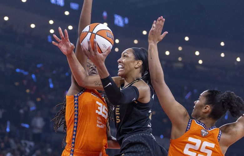 Las Vegas Aces forward A’ja Wilson, center, gets inside of Connecticut Sun forwards Jonquel Jones (35) and Alyssa Thomas (25) for a shot during the first half in Game 1 of a WNBA basketball final playoff series Sunday, Sept. 11, 2022, in Las Vegas. (AP Photo/L.E. Baskow) NVLB102 NVLB102