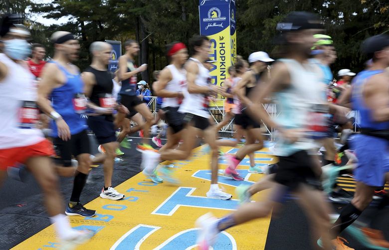 FILE – Runners cross the starting line of the 125th Boston Marathon, Monday, Oct. 11, 2021, in Hopkinton, Mass. Nonbinary athletes will be able to run in next year’s Boston Marathon without having to qualify for the men’s or women’s divisions, race organizers announced Monday, Sept. 12, 2022. (AP Photo/Mary Schwalm, File) NY153 NY153