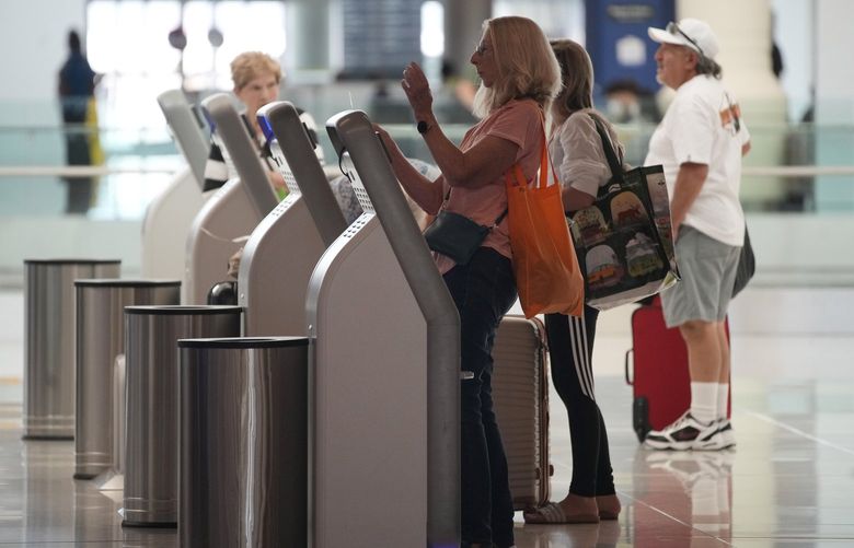 Travelers queue up at self-service kiosks to check in for flights on Southwest Airlines in Denver International Airport as the Labor Day holiday approaches Tuesday, Aug. 30, 2022, in Denver. (AP Photo/David Zalubowski) CODZ107 CODZ107