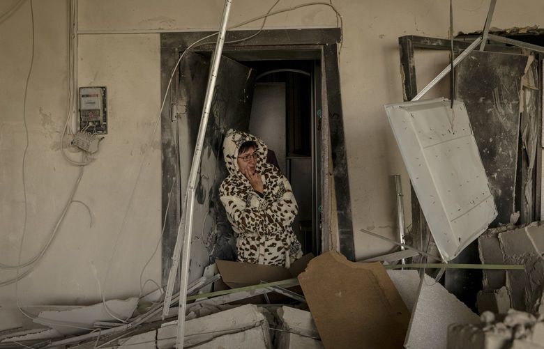 A woman in the doorway of her damaged home the morning after strikes on her residential building in Kharkiv, Ukraine, Sept. 12, 2022. Russian strikes on the city have knocked out power to thousands of civilians. (Nicole Tung/The New York Times) XNYT29 XNYT29