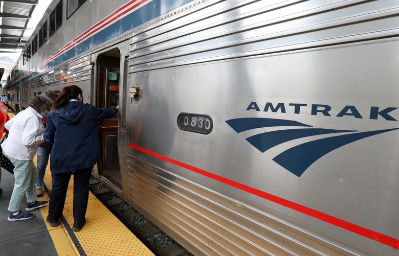 A passenger is helped aboard Amtrak’s long-distnace Empire Builder train service to Chicago at King Street Station, Tuesday, May 25, 2021 in Seattle. 217237