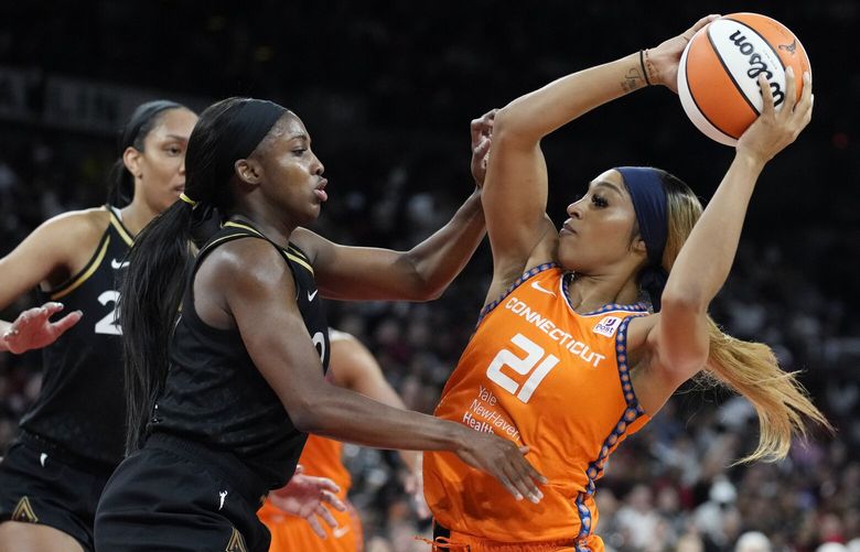 Connecticut Sun guard DiJonai Carrington (21) attempts to shoot around Las Vegas Aces guard Jackie Young (0) during the second half in Game 2 of a WNBA basketball final playoff series Tuesday, Sept. 13, 2022, in Las Vegas. (AP Photo/John Locher) NVJL120 NVJL120