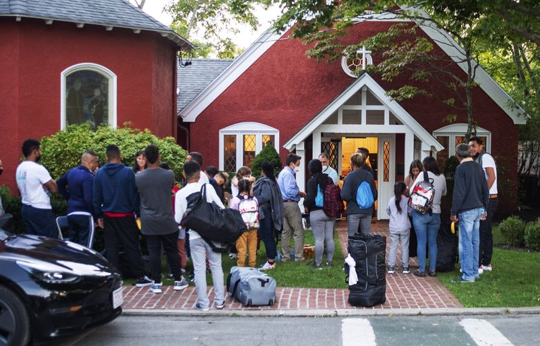 Immigrants gather with their belongings outside St. Andrews Episcopal Church, Wednesday Sept. 14, 2022, in Edgartown, Mass., on Martha’s Vineyard. Florida Gov. Ron DeSantis on Wednesday flew two planes of immigrants to Martha’s Vineyard, escalating a tactic by Republican governors to draw attention to what they consider to be the Biden administration’s failed border policies. (Ray Ewing/Vineyard Gazette via AP) MAMVY104 MAMVY104