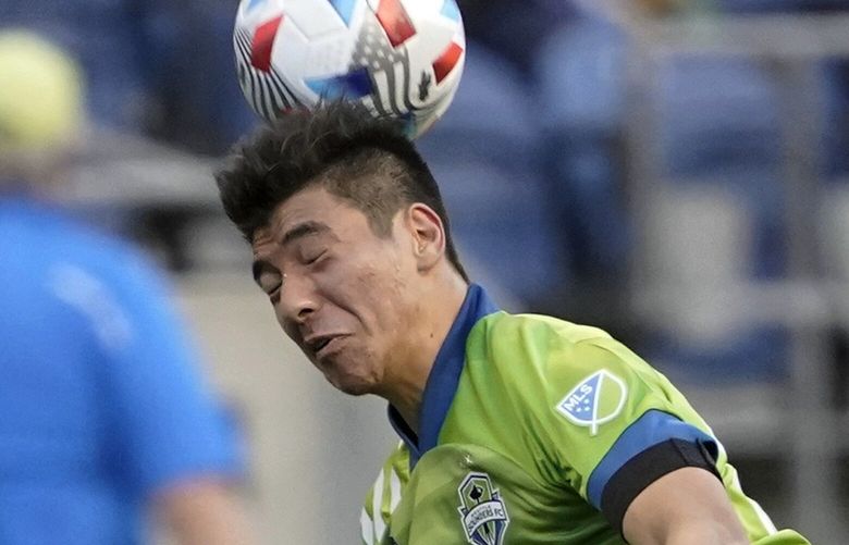 Seattle Sounders midfielder Josh Atencio heads the ball as he lands on Minnesota United midfielder Emanuel Reynoso during the first half of an MLS soccer match, Friday, April 16, 2021, in Seattle. (AP Photo/Ted S. Warren)