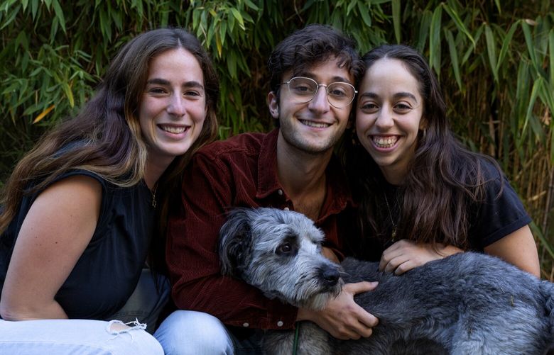 From left: housemates Madison Holt, 22; Ari Rosenthal, 24; and Clara Prizont, 24, with Holt’s dog Leo in the backyard of Moishe House, Tuesday, Sept. 20, 2022 in Seattle.