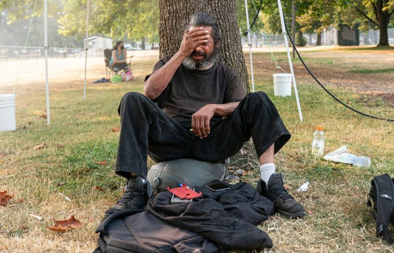 In this file photo, a homeless man who asked to not be named tries to stay cool near a misting station in Lents Park during an extreme heat wave in Aug. 13, 2021 in Portland, Oregon. (Nathan Howard/Getty Images/TNS)
