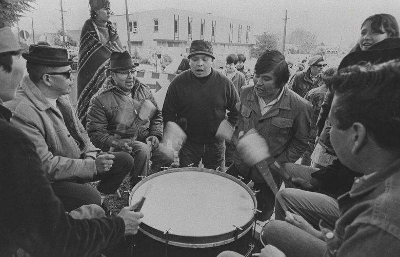 Times file, ran March 16, 1970. Members of the United Indians of All Tribes chanted and kept a rhythm for dancing pickets outside the main gate at Fort Lawton.