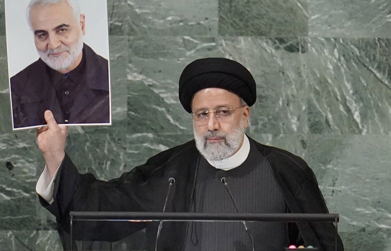 President of Iran Ebrahim Raisi holds up a photo of slain Iranian Gen. Qassem Soleimani as he addresses the 77th session of the United Nations General Assembly, Wednesday, Sept. 21, 2022 at U.N. headquarters. (AP Photo/Mary Altaffer) UNMA117 UNMA117