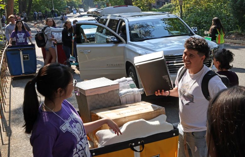 Angel Casillas (right), a freshman from Yakima, WA, gets help from student volunteer Angel Lee (left) and his family as he moves into the McMahon Hall at the University of Washington in Seattle, WA on September 21, 2022. Around 10,000 students are expected to move into campus housing throughout the week. Fall quarter classes start on September 28th. 221621