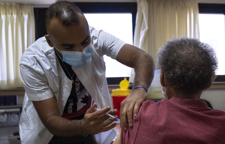 A man receives the fifth Pfizer-BioNTech COVID-19 vaccine from medical staff at Clalit Health services in Tel Aviv, Israel, Thursday, Sept. 22, 2022. Israel has launched its fifth vaccination campaign, urging people in at-risk groups and those over 65 to get the additional COVID shot. The fifth vaccine available to Israelis is one that specifically targets the Omicron strain of the coronavirus, which makes up the majority of cases in the country.(AP Photo/Oded Balilty) XOB102 XOB102