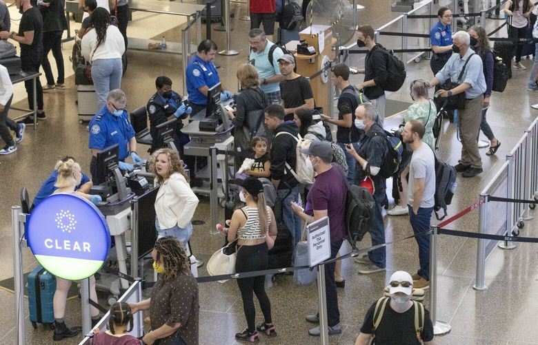 Travelers wait in long security lines at Seattle-Tacoma International Airport Friday, July 1, 2022 at the start of the 4th of July weekend.  Flights are more expensive but a lot of people are still traveling. 220887