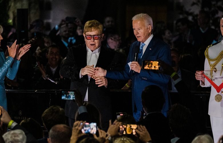President Joe Biden presents Elton John with the National Humanities Medal, which is meant to honor people or groups whose work deepens American access to cultural experiences in fields including the performing arts, on the South Lawn of the White House in Washington, Friday, Sept. 23, 2022. Biden’s predecessor, former President Donald Trump, had sought such an appearance by the British pop superstar, but never received one. (Gabriela Bhaskar/The New York Times) XNYT292 XNYT292
