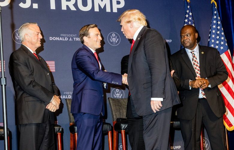 FILE – Adam Laxalt, the Republican candidate for Senate in Nevada, shakes hands with former President Donald Trump at a rally in Las Vegas on July 8, 2022. From the week of Aug. 14 to the week of Nov. 6, Laxalt had only $6 million in television reservations. (Roger Kisby/The New York Times) XNYT134 XNYT134