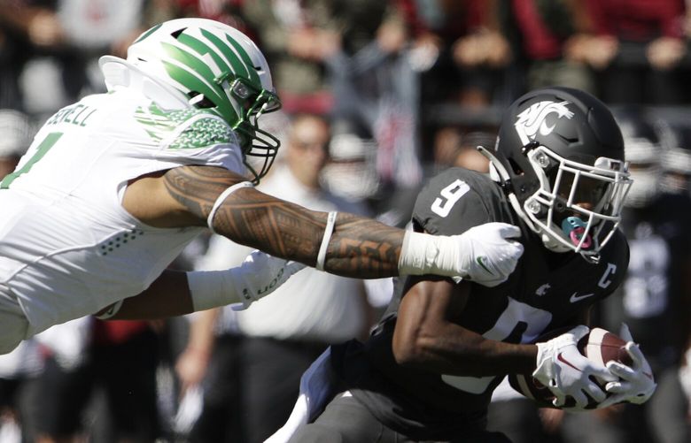 Washington State wide receiver Renard Bell (9) tries to get past Oregon linebacker Noah Sewell (1) during the first half of an NCAA college football game, Saturday, Sept. 24, 2022, in Pullman, Wash. (AP Photo/Young Kwak) WAYK103 WAYK103