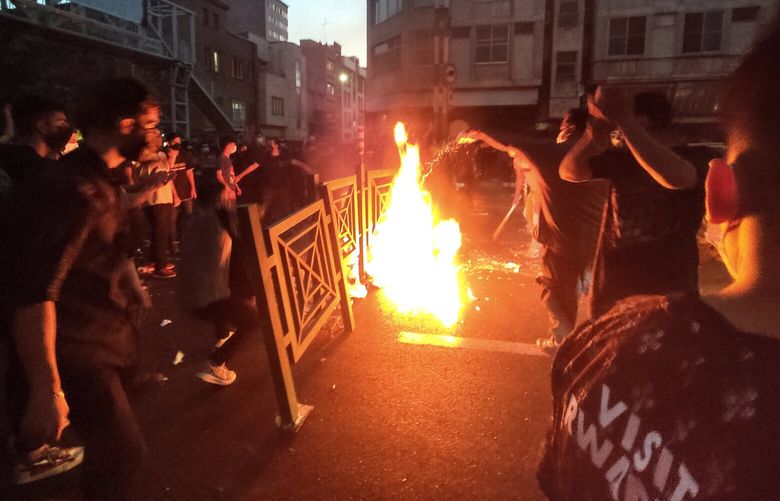 In this Wednesday, Sept. 21, 2022, photo taken by an individual not employed by the Associated Press and obtained by the AP outside Iran, protesters make fire and block the street during a protest over the death of a woman who was detained by the morality police, in downtown Tehran, Iran. Iranians saw their access to Instagram, one of the few Western social media platforms still available in the country, disrupted on Wednesday following days of the mass protests. (AP Photo) NY104 NY104