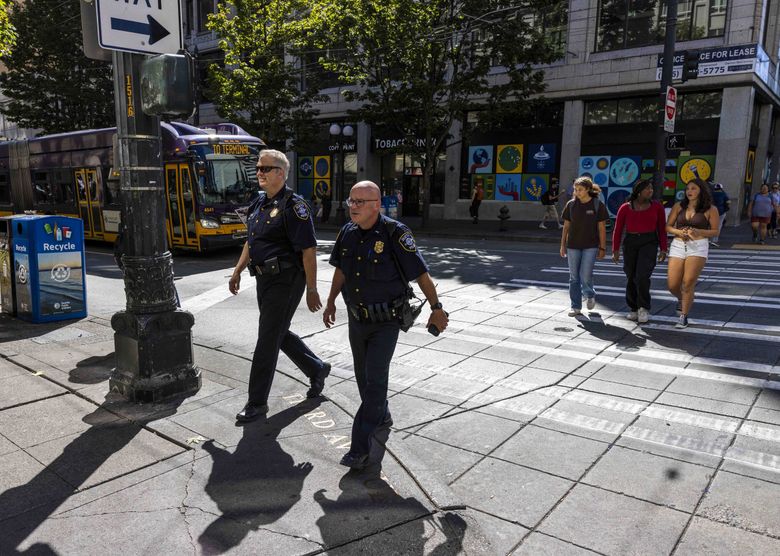 Seattle police Capt. Steve Strand, left, and Lt. Rob Brown patrol the intersection of Third Avenue and Pine Street in Seattle on Sept. 7. This area is also known colloquially as “the Blade.” (Daniel Kim / The Seattle Times)