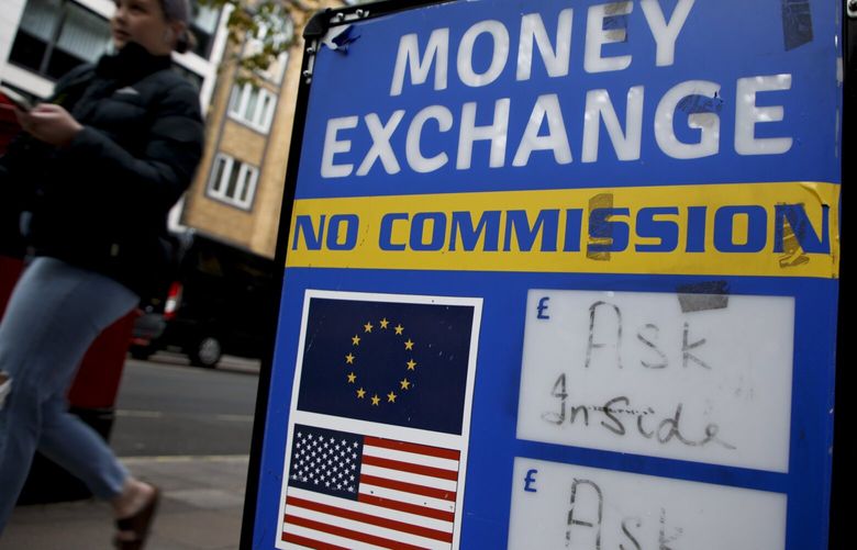 A woman walks past a currency exchange bureau in London, Monday, Sept. 26, 2022. The pound today slumped to its lowest level against the dollar since 1971, after the Chancellor hinted more tax cuts would follow those he announced last week. The pound dipped as low as $1.0349 per U.S. dollar early Monday but then rebounded to $1.0671, down 2.3%. (AP Photo/David Cliff) LDC126 LDC126