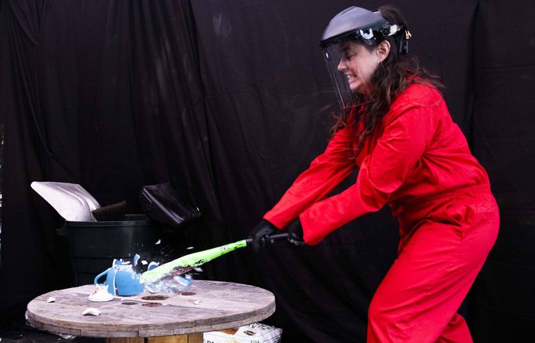 Rebecca Gold destroys a trinket with her might with a bat at a pop-up tent for Smash(It) Seattle in front of Wheelie Pop Brewing in Ballard on Sept. 24, 2022.