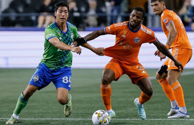 Seattle Sounders FC midfielder Josh Atencio tries to slow down FC Cincinnati defender Alvas Powell by grabbing his jersey during the second half. 221654