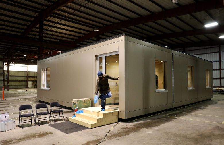 People leave a tour of the Forterra-built prototype modular unit in a warehouse in Everett.  Forterra, a nonprofit land trust, is teaming up with Snohomish County and Darrington to create the Darrington Wood Innovation Center to create jobs and support housing production in a sustainable way. 

Friday January 28, 2022 219437 (Alan Berner / The Seattle Times)