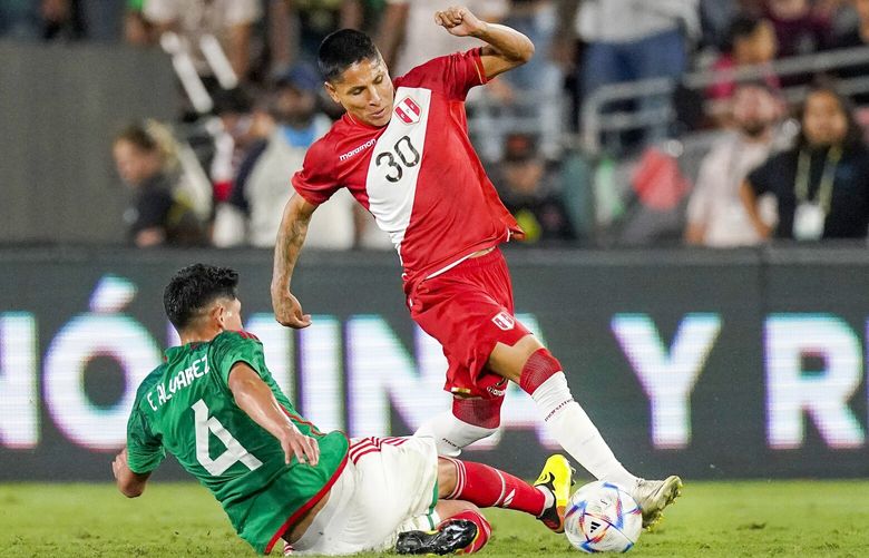Peru forward Raul Ruidiaz, right, takes the ball as Mexico midfielder Edson Alvarez tries to kick it away during the second half of a soccer match Saturday, Sept. 24, 2022, in Pasadena, Calif. (AP Photo/Mark J. Terrill) PRB116