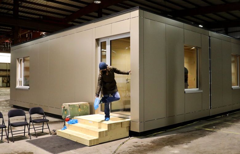 People leave a tour led by Forterra of a prototype modular housing unit in a warehouse in Everett. The Snoqualmie Indian Tribe has flagged problems with Forterra’s application for a federal grant for a timber and housing project. (Alan Berner / The Seattle Times)