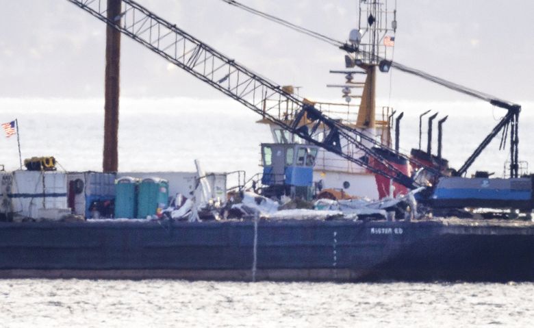 A barge holding wreckage from the  floatplane that crashed in September sits on anchor in Mutiny Bay on Thursday off Whidbey Island.  (Karen Ducey / The Seattle Times)