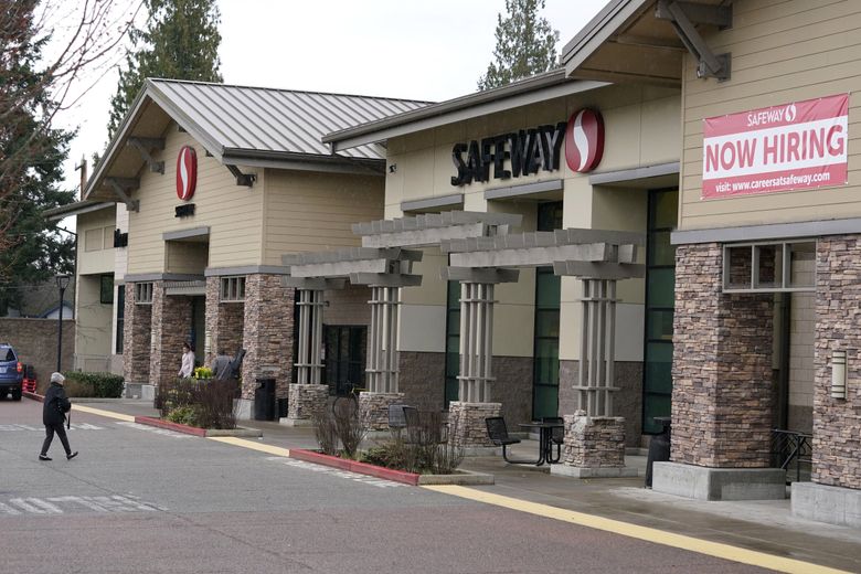 A sign reads “Now Hiring” at a Seattle Safeway grocery store in 2021. Those signs are still a familiar sight in 2022. (Ted S. Warren / AP)
