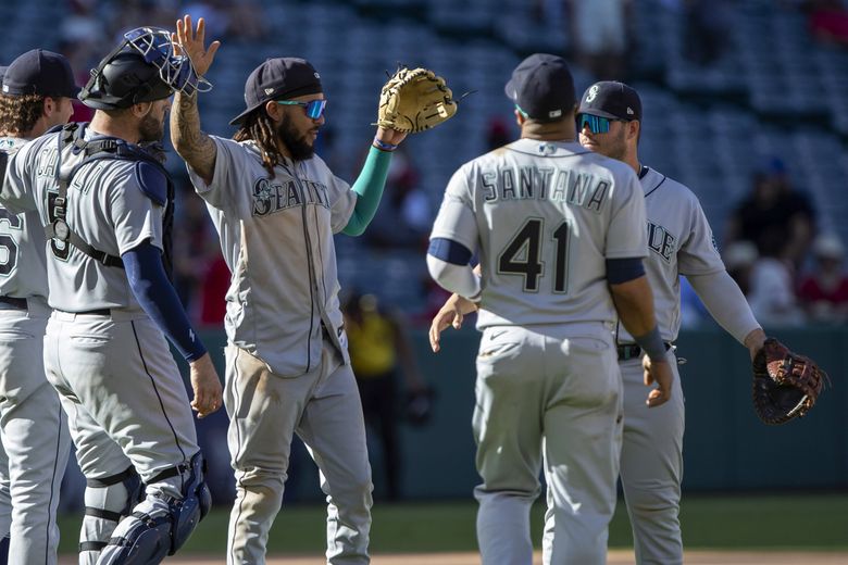 Seattle Mariners shortstop J.P. Crawford, center, celebrates with teammates after the Mariners win a baseball game against the Los Angeles Angels in Anaheim, Calif., Monday, Sept. 19, 2022. (AP Photo/Alex Gallardo) 