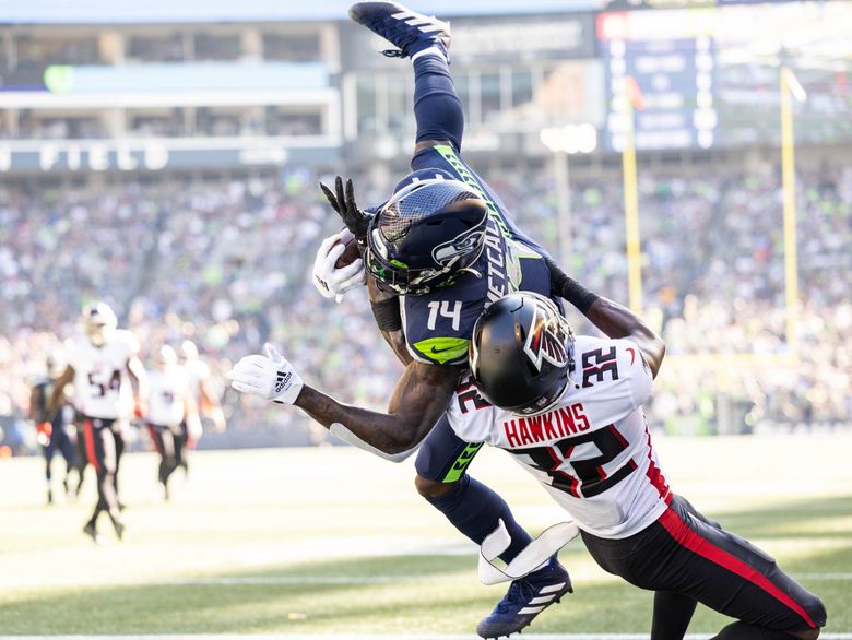 DK Metcalf holds on to the touchdown pass from Geno Smith in the second quarter, beating Atlanta’s Jaylinn Hawkins on the 18-yard play. (Dean Rutz / The Seattle Times)