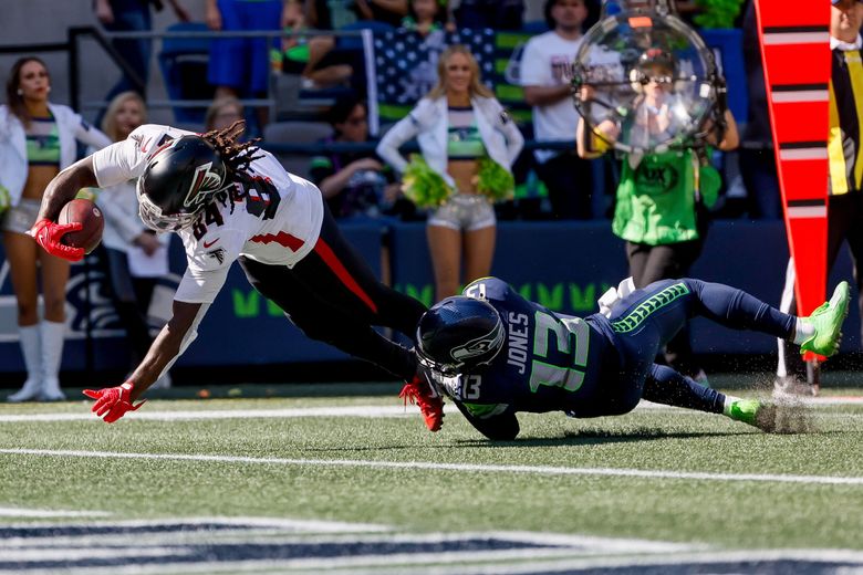 Atlanta Falcons running back Cordarrelle Patterson dives past Seattle Seahawks safety Josh Jones for a 17-yard touchdown during the second quarter, Sunday, Sept. 25, 2022, in Seattle. (Jennifer Buchanan / The Seattle Times)