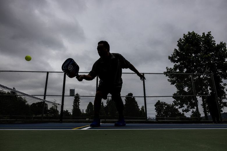 Lawrence Lee, 58, practices with his buddy Dennis Rock (not pictured) at Lakeridge Playfield on July 2, 2022. Pickleball is the official sport of the state of Washington. The game was invented on Bainbridge Island in 1965. (Daniel Kim / The Seattle Times)