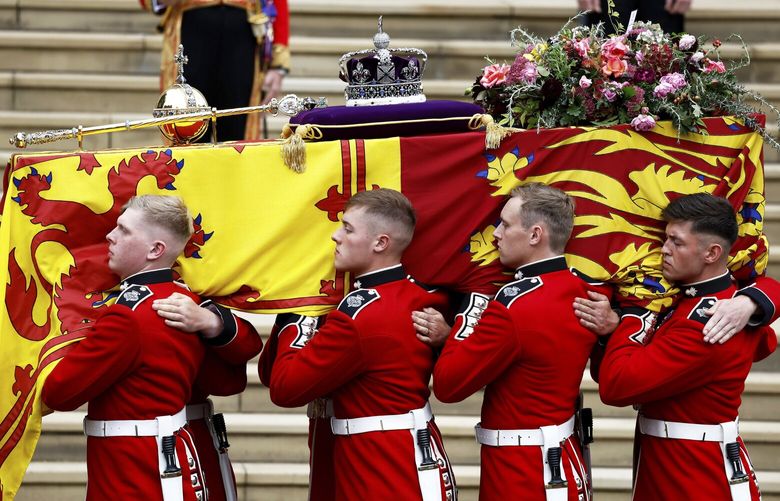 Pall bearers carry the coffin of Queen Elizabeth II with the Imperial State Crown resting on top into St. George’s Chapel, in Windsor, England, Monday Sept. 19, 2022, for the committal service for Queen Elizabeth II. The Queen, who died aged 96 on Sept. 8, will be buried at Windsor alongside her late husband, Prince Philip, who died last year.  (Jeff J Mitchell/Pool Photo via AP) AMB289 AMB289