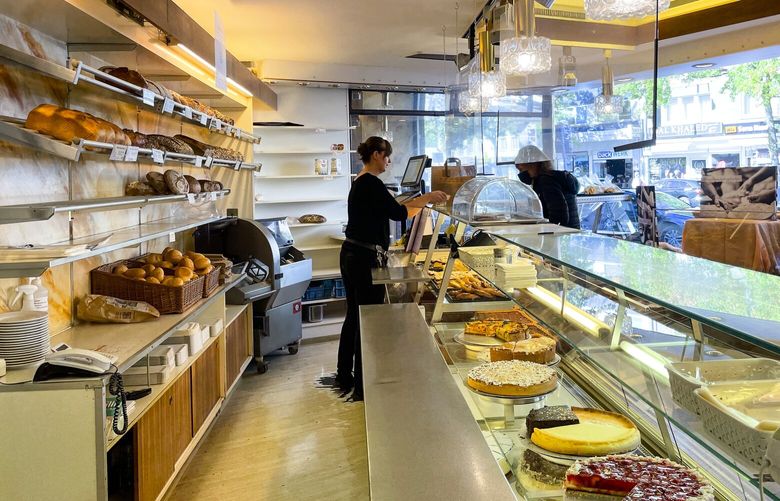 An employee serves a customer at the family bakery of Engelbert Schlechtrimen in Cologne, Germany, Wednesday, Sept. 21, 2022. For 90 years, the family of Engelbert Schlechtrimen has been baking wheat rolls, rye bread, apple, cheese and chocolate cakes in Cologne, but next month they’ll turn off the ovens for good because they can no longer afford the rising energy prices resulting from Russia’s war in Ukraine. (AP Photo/Daniel Niemann) DAN105 DAN105