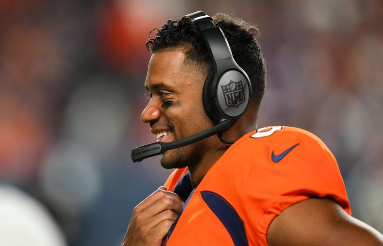 Denver Broncos quarterback Russell Wilson looks on from the sidelines wearing a headset against the Minnesota Vikings during an NFL preseason football game, Saturday, Aug. 27, 2022, in Denver. (AP Photo/Jack Dempsey) OTK OTK
